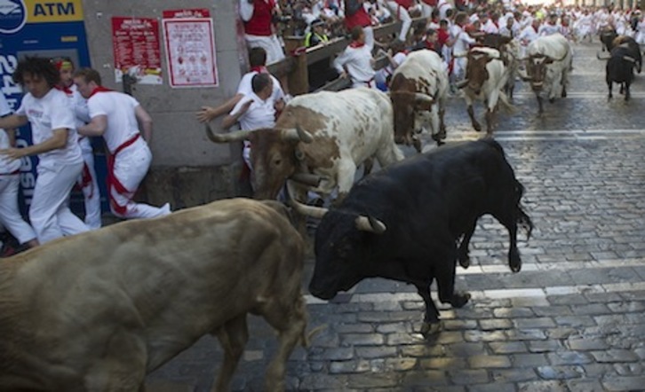 Los astados toman limpiamente la curva de Estafeta a pesar de que el suelo estaba mojado. (Jagoba MANTEROLA/ARGAZKI PRESS)