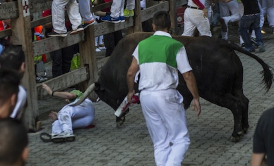 Un toro suelto se lanza por un corredor caído en el callejón. (Jagoba MANTEROLA/ARGAZKI PRESS) Un toro suelto se lanza por un corredor caído en el callejón. (Jagoba MANTEROLA/ARGAZKI PRESS)