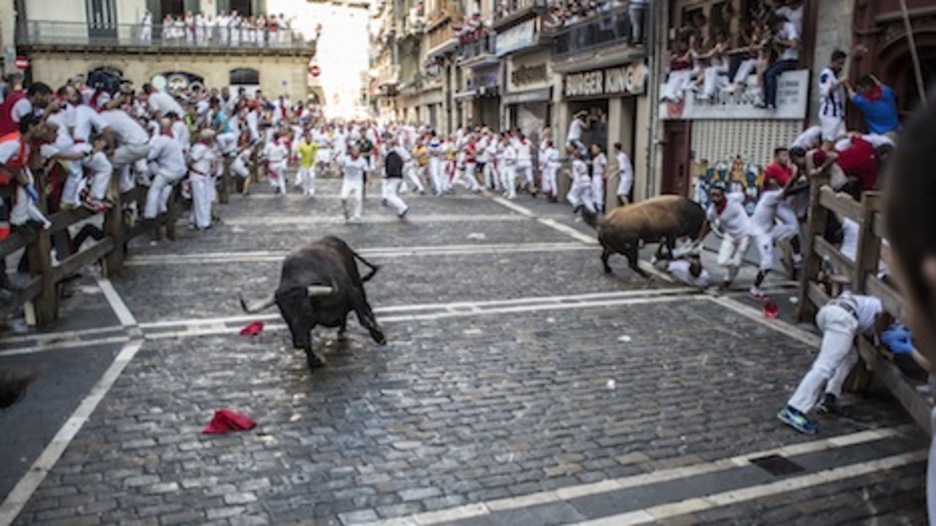 Un astado suelto embiste a un corredor, mientras otro burel patina en Mercaderes. (Lander ARROYABE/ARGAZKI PRESS)