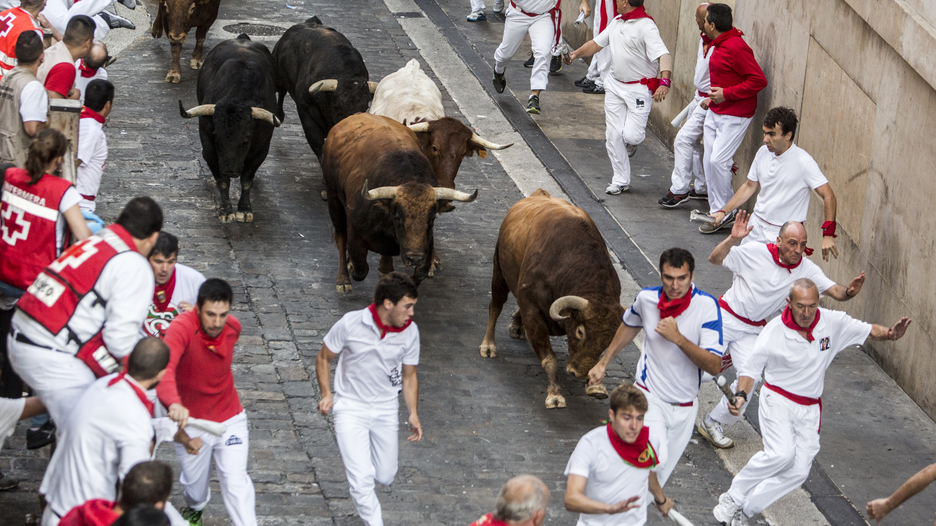 El toro colorado que abría la manada lanza un derrote a la altura del Ayuntamiento. (Lander ARROYABE/ARGAZKI PRESS)