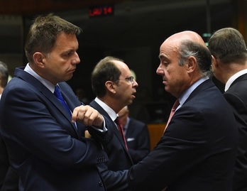 El presidente de turno del Ecofin y ministro eslovaco de Finanzas, Peter Kazimir, conversa con el titualr español de Economía, Luis de Guindos. (JOHN THYS / AFP) 
