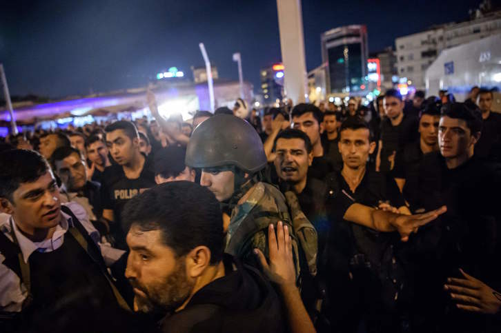 Policías y ciudadanos rodean a un soldado. (Ozan KOSE/AFP)