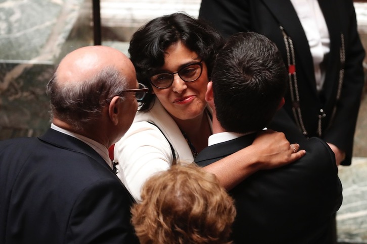 Manuel Valls besa a la ministra Myriam El-Khomri, cuyo nombre lleva la ley de reforma del trabajo, tras la sesión parlamentaria. (François GUILLOT/AFP) 