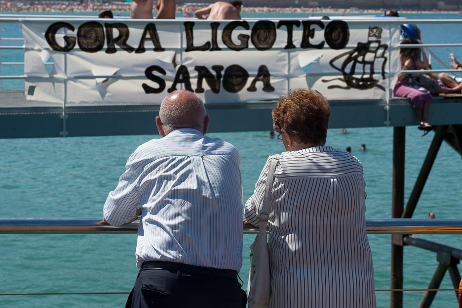 Agure bikote bat, portuko pankarta bati begira. (Iñigo URIZ/ARGAZKI PRESS)