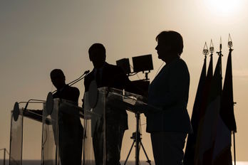 La fotografía recoge la silueta de los tres líderes europeos, en penumbra. (Guido BERGMANN / AFP)