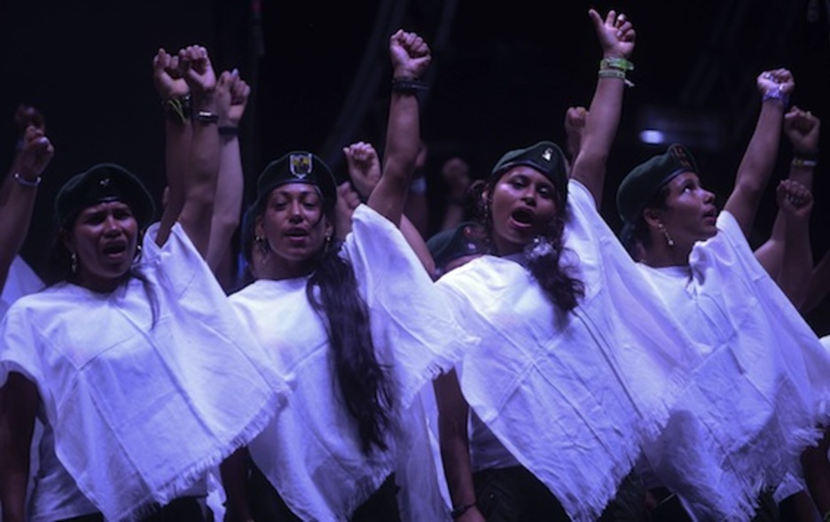 Un coro formado por integrantes de las FARC-EP cantan para dar la bienvenida al acuerdo. (Raúl ARBOLEDA/AFP)