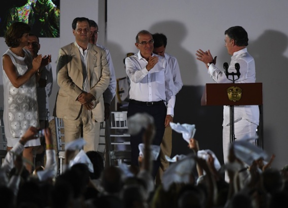 Santos aplaude a Humberto de la Calle, quien ha encabezado el equipo negociador del Gobierno colombiano. (Luis ACOSTA/AFP)