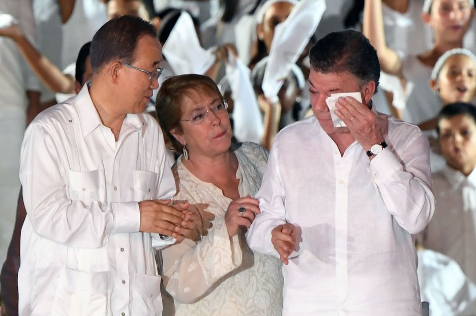 Santos, emocionado, junto a Ban Ki-moon y la presidenta chilena, Michelle Bachellet. (Luis ACOSTA/AFP)