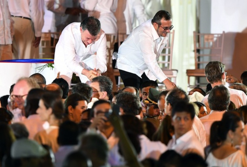 Santos y ‘Timochenko’ saludan a los asistentes. (Luis ACOSTA/AFP)