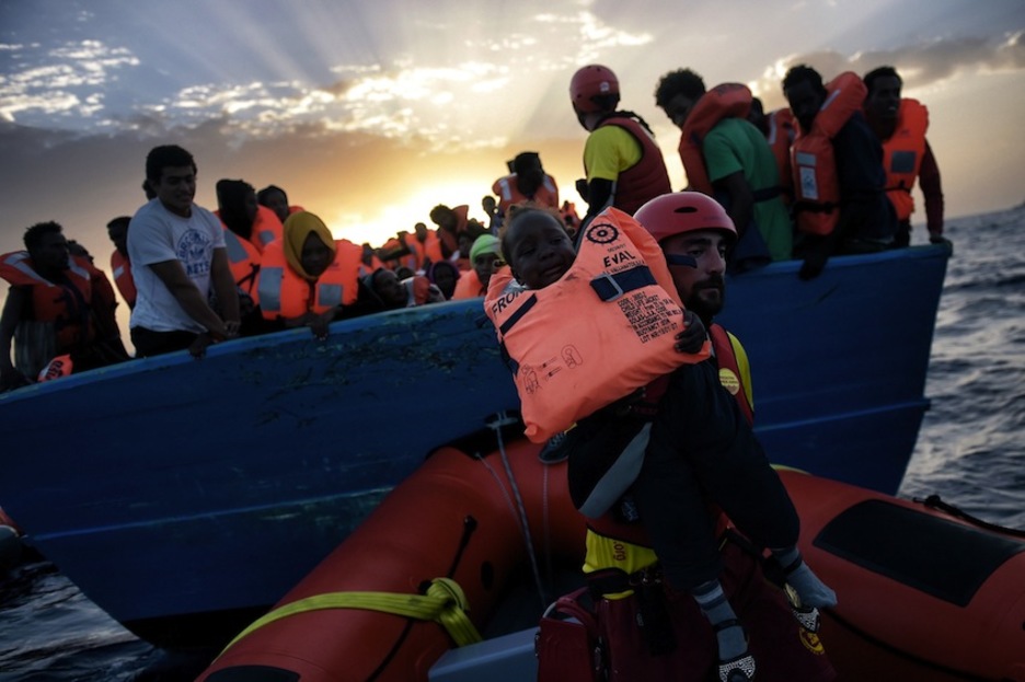 Un niño es rescatado de una embarcación repleta de inmigrantes. (Aris MESSINIS / AFP)