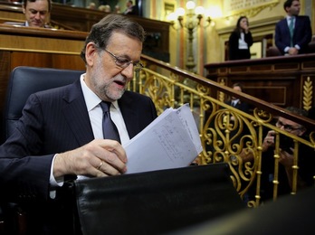 Mariano Rajoy saca unos papeles de su cartera durante la sesión de investidura. (J.DANAE / ARGAZKI PRESS)