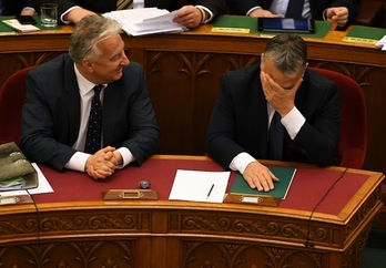 El primer ministro húngaro, Viktor Orban, se tapa la cara durante un momento de la sesión parlamentaria. (Attila KISBENEDEK/AFP)