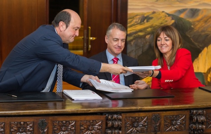 Ortuzar y Mendia intercambian los documentos para firmarlos ante la presencia de Urkullu. (Juanan RUIZ/ARGAZKI PRESS)
