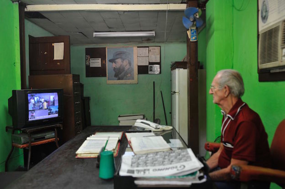 Un hombre sigue por televisión la programación especial sobre la figura de Castro. (Pedro PARDO / AFP)