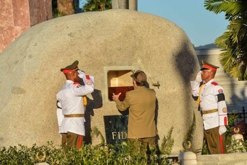 Raúl Castro introduce la urna con las cenizas de Fidel en el interior de una roca de Sierra Maestra, en el cementario Santa Ifigenia. (Marcelino/VÁZQUEZ/AFP)