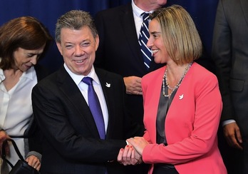 Saludo entre el mandatario Juan Manuel Santos y la jefa de la diplomacia comunitaria, Federica Mogherini. (Emmanuel DUNAND/AFP)