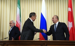 Sergei Lavrov saluda a Mevlut Cavusoglu en presencia de su homólogo iraní, Mohamad Yavad Zarif. (Natalia KOLESNIKOVA/AFP)