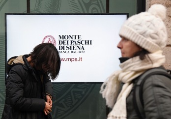Dos mujeres pasan junto a una oficina de la entidad Monte dei Paschi en Roma. (Tiziana FABI/AFP)
