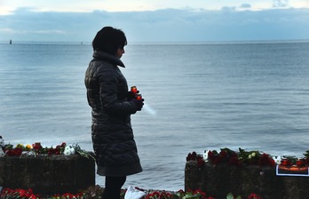 Una mujer enciende unas velas en Sochi en memoria de las víctimas del accidente. (Vasily MAXIMOV/AFP) 