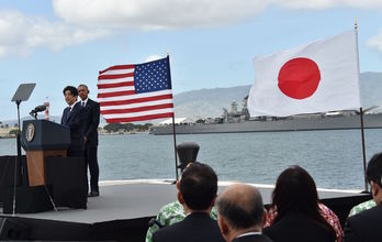 Los mandatarios japonés y estadounidense junto a sus banderas. (Nicholas KAMM/AFP) 