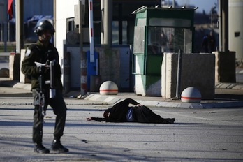 Una mujer palestina yace herida en el suelo tras haber recibido disparos por parte de las fuerzas israelíes. (Abbas MOMANI/AFP)