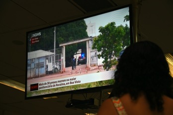 Una mujer escucha noticias sobre el motín en la televisión. (Vanderelei ALMEIDA/AFP) 