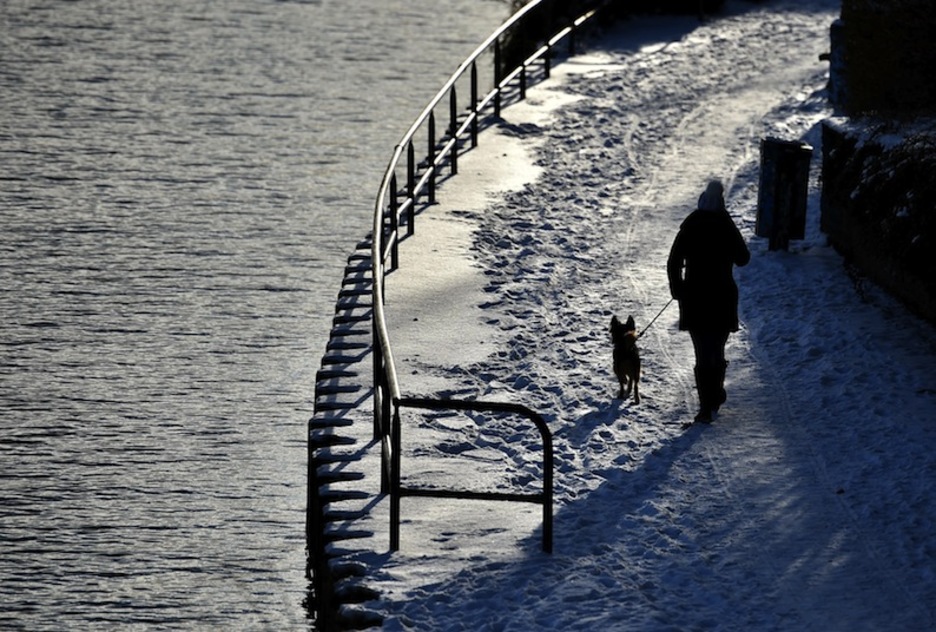 Emakume bat ibai ondoan paseatzen, Berlinen. (Britta PEDERSEN/AFP)