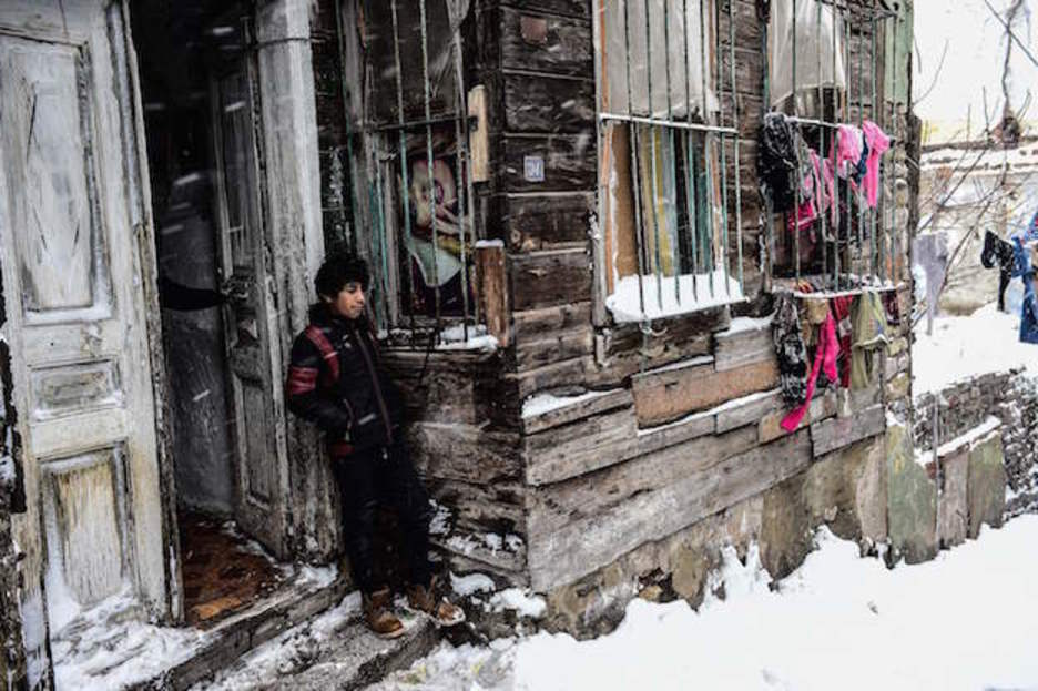 Un menor sirio a la puerta del lugar en el que vive cerca de Estambul, en Turquía. (YASIN AKGUL / AFP) 