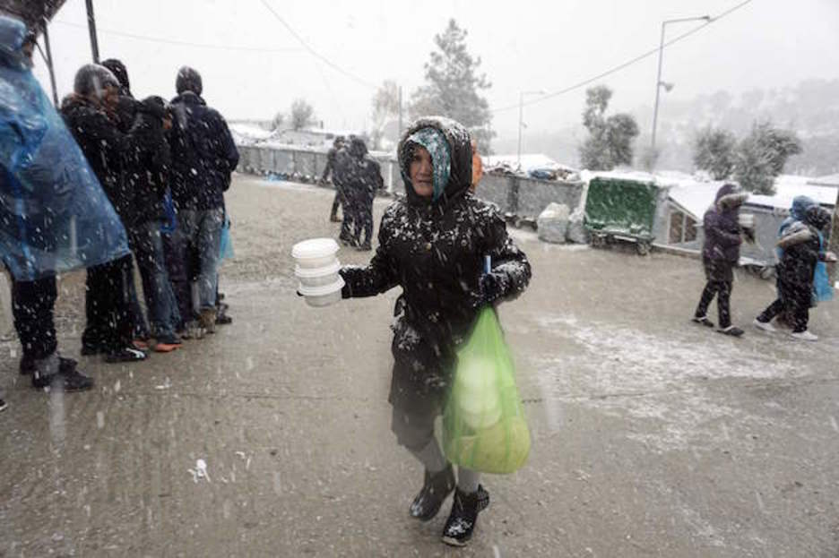 Una mujer, con recipientes de comida en Lesbos. (AFP PHOTO / STR)
