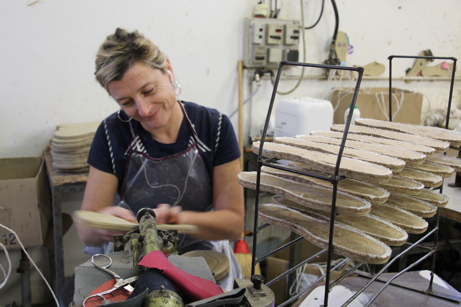 Les espadrilles passent par les mains de la colleuse de semelles. @Caroline MALCZUK