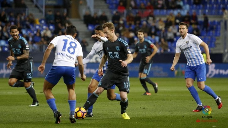 Zurutuza trata de escapar del acoso de varios jugadores del Málaga. (@LaLiga)