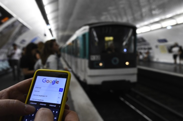 Un usuario se conecta a internet desde su teléfono móvil en el metro de París. (Bertrand GUAY/AFP)