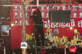 Agentes de la Ertzaintza retirando caricaturas de las fotos de presos de la txosna de Kaskagorri. (Juanan RUIZ / ARGAZKI PRESS) 