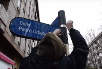 Un integrante de Ernai quita la placa de la calle Pedro Orbea, en Gasteiz. 