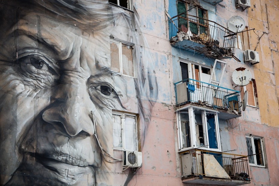 Un edificio de Avdiivka con el retrato de una profesora local. El edificio tiene numerosos impactos. (Juan TEIXEIRA)