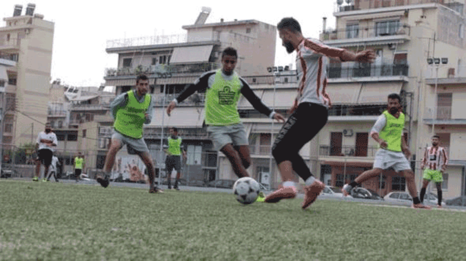 El equipo Hope Refugees, con la ayuda del vicepresidente del Olimmpiacos.