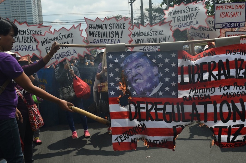 Donald Trump AEBetako presidentearen irudian duen bandera erre dute Manilan. (Ted ALJIBE/AFP)