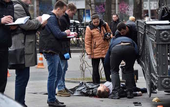 Policías ucranianos inspeccionan el cadáver de Voronenkov. (Sergei SUPINSKY / AFP)