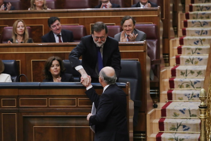 Apretón de manos entre el presidente Rajoy y su ministro de Hacienda, Cristóbal Montoro, en un pleno anterior. (J.DANAE/ARGAZKI PRESS)