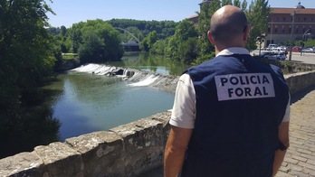 La Policía Foral se ha hecho cargo de las investigaciones. Un agente junto al puente de Santa Engracia. (FORUZAINGOA)