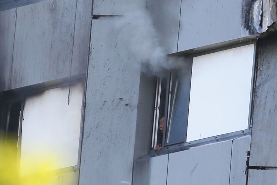 Un hombre busca aire respirable a través de una ventana. (DANIEL LEAL-OLIVAS / AFP)  