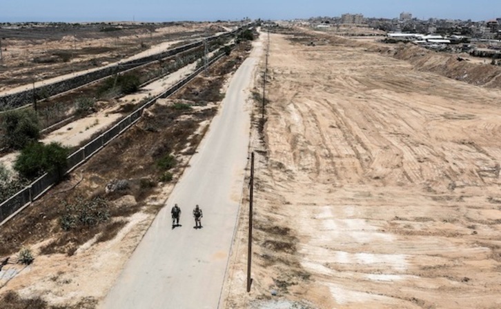 Dos miembros de las fuerzas de seguridad de Gaza patrullan la zona fronteriza con Egipto. (Said KHATIB/AFP)