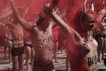 El polvo rojo cubre a los activistas de AnimaNaturalis y PETA tras romper las banderillas por los toros que morirán en sanfermines. (Jagoba MANTEROLA/ARGAZKI PRESS)