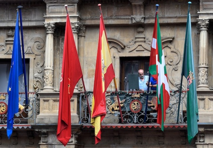 Trabajadores municipales colocan la ikurriña en el balcón del Ayuntamiento. (Ander GILLENEA/AFP)