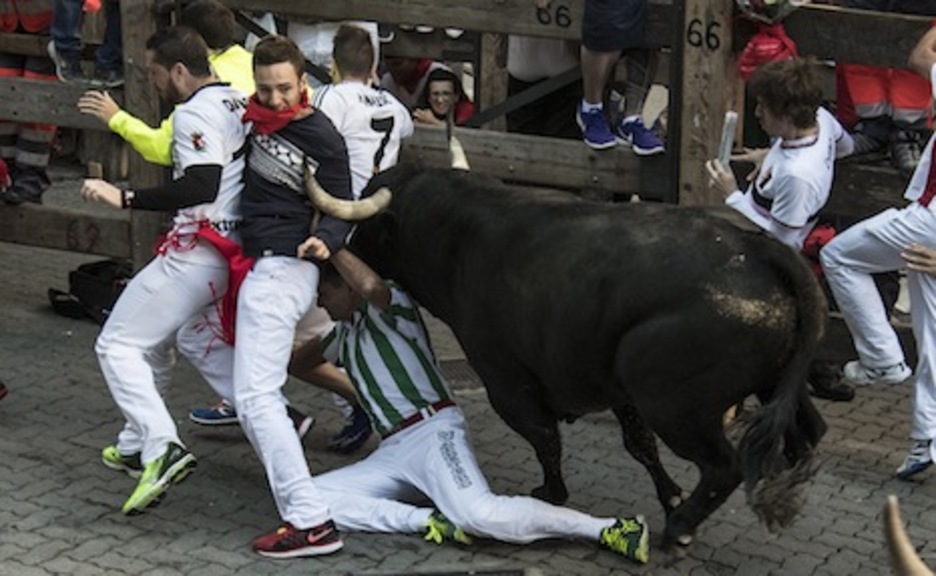 El primer corredor cae al suelo, mientras el toro alcanza al grupo delantero de corredores. (Jagoba MANTEROLA/ARGAZKI PRESS) El primer corredor cae al suelo, mientras el toro alcanza al grupo delantero de corredores. (Jagoba MANTEROLA/ARGAZKI PRESS)