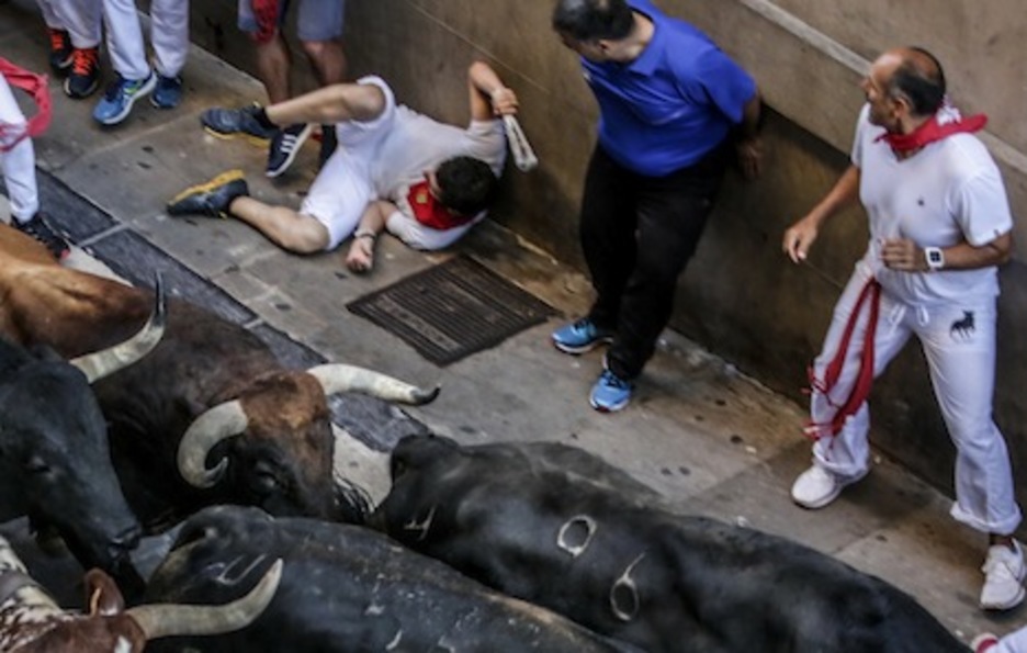 Un mozo rueda por el suelo, mientras otros hacen la ‘estatua’ al paso de la torada. (Lander FERNANDEZ DE ARROYABE/ARGAZKI PRESS) Un mozo rueda por el suelo, mientras otros hacen la ‘estatua’ al paso de la torada. (Lander FERNANDEZ DE ARROYABE/ARGAZKI PRESS)