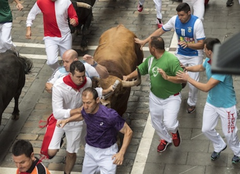 El toro Fundador alcanza a varios corredores a la altura de Espoz y Mina, donde se produjo la segunda cornada del día. (Juanan RUIZ/ARGAZKI PRESS) El toro Fundador alcanza a varios corredores a la altura de Espoz y Mina, donde se produjo la segunda cornada del día. (Juanan RUIZ/ARGAZKI PRESS)