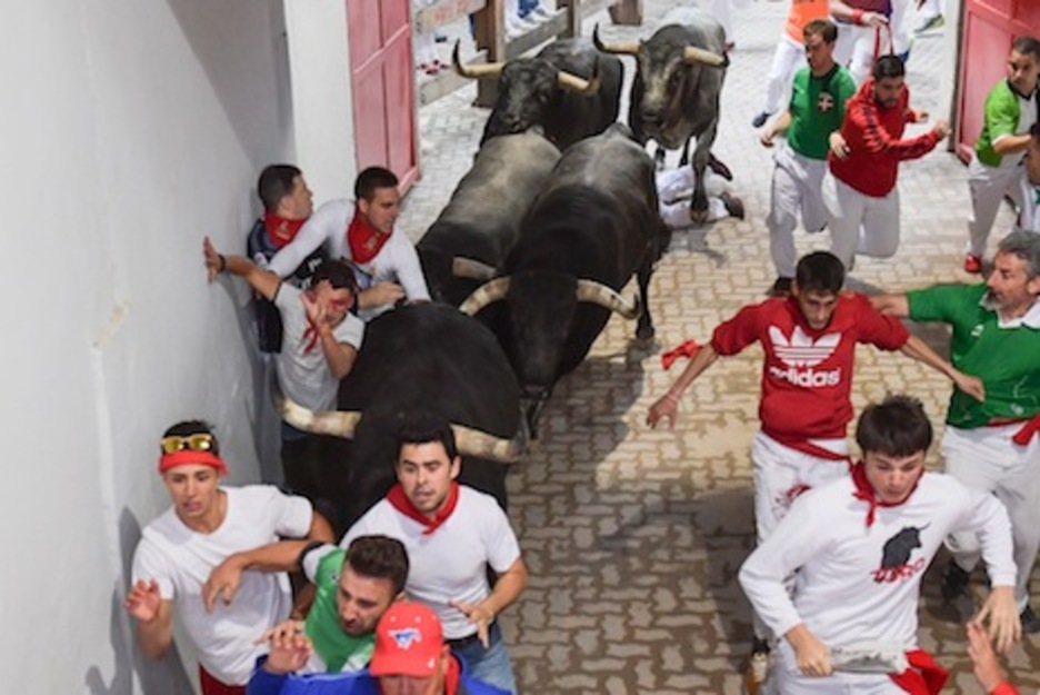 Dos corredores pasan por apuros al ser arrinconados contra la pared por los morlacos. (Idoia ZABALETA/ARGAZKI PRESS)