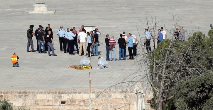 Fuerzas policiales israelíes junto al cadáver de uno de los palestinos abatidos en Jerusalén. (Thomas COEX/AFP)