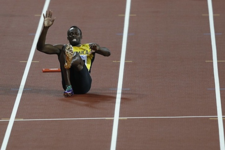 Usain Bolt, con gesto dolorido, sobre la pista de Londres. (Adrian DENNIS/AFP)
